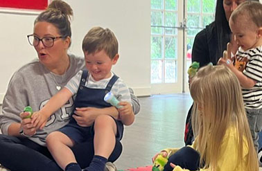 a group of children sitting around a matt for a birthday party sensory storytelling session