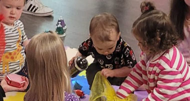 a group of children looking through different objects within a sensory experience class